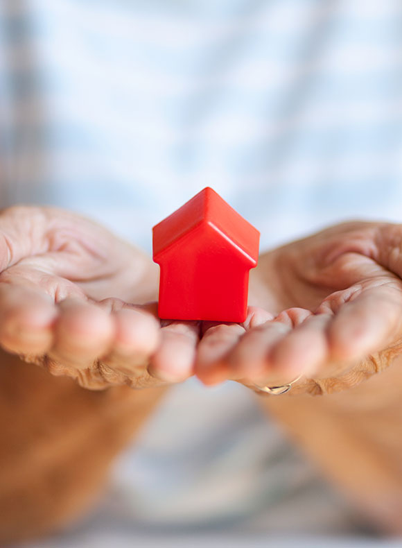 Woman holding toy home in her hands