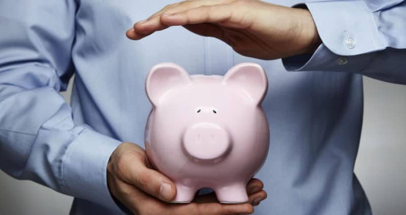 Man holding a pink porcelain piggy bank