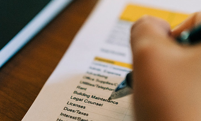 Close up of hand an ben scanning a legal spreadsheet