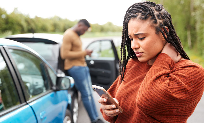 Man and Woman using cell phones after car crash