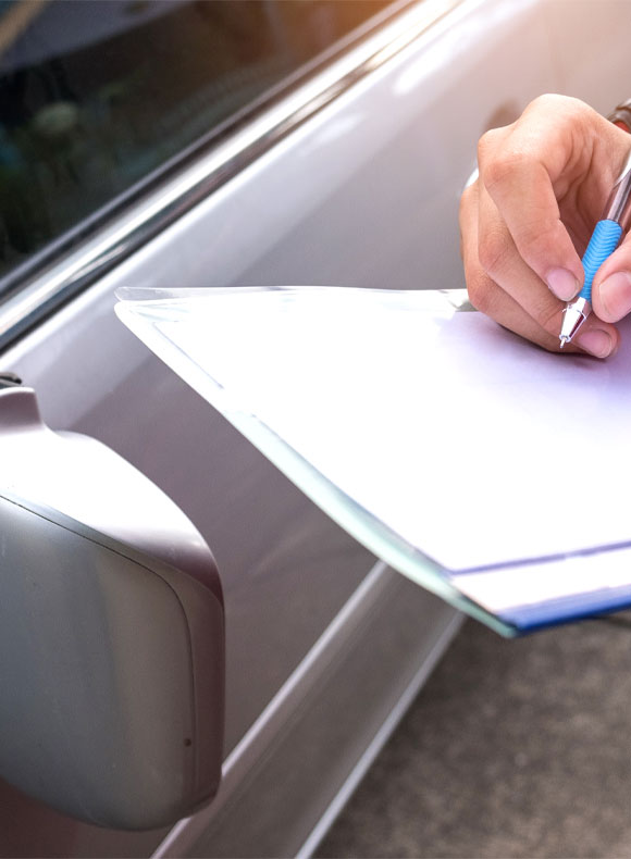 Person Using Pen and Paper After a Car Accident with Silver Vehicle