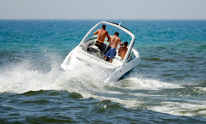 Three people riding in boat on open water.